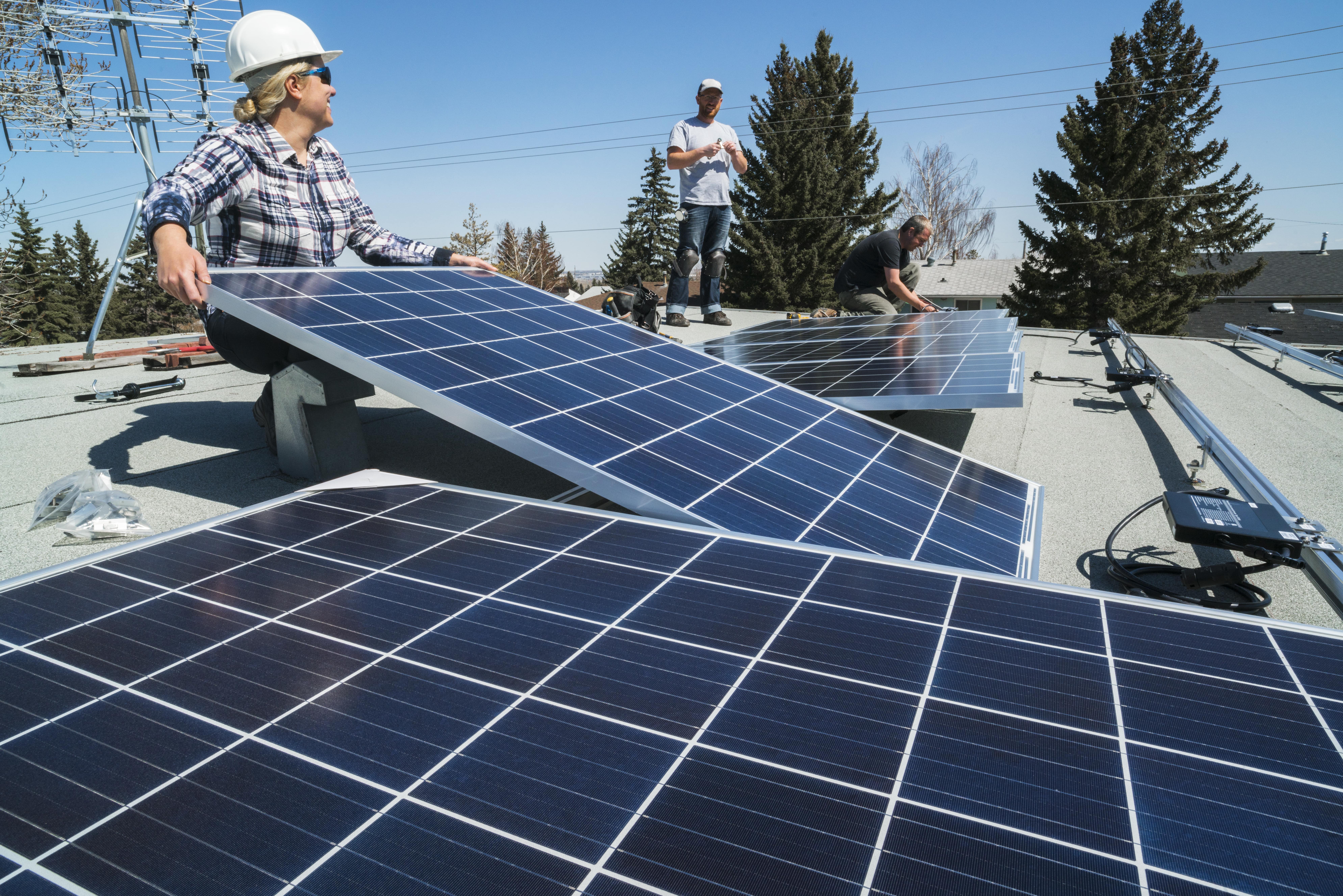 Un groupe de travailleurs installant des panneaux solaires sur un toit